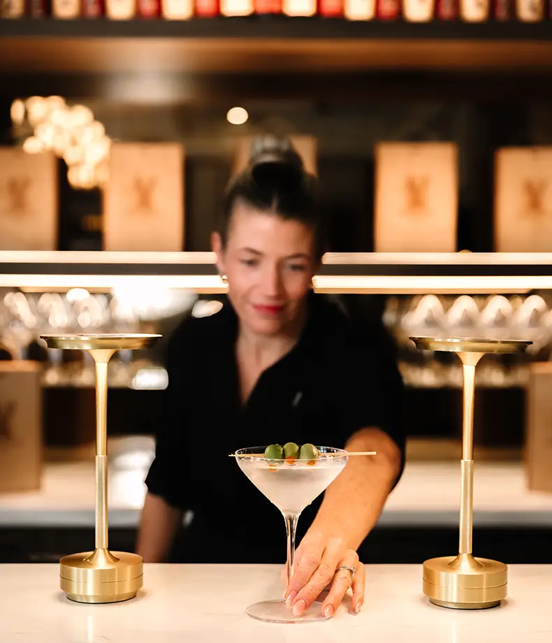 Lady bartender serving a cocktail at Stone Eagle Winery .